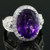 A modern 18k white gold, amethyst and diamond set dress ring, with diamond set shoulders and