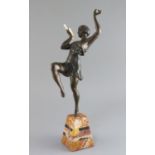 Attributed to G. Limousin. A bronzed metal and ivory figure of a pan pipe dancer, on two colour