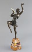 Attributed to G. Limousin. A bronzed metal and ivory figure of a pan pipe dancer, on two colour