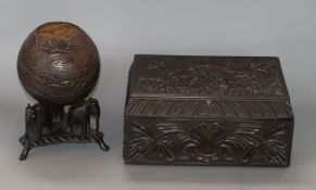 A Ceylonese carved ebony box and a coconut shell and 'elephant' stand