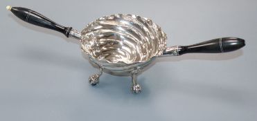 A Continental white metal two handled spiral decorated tasting bowl, on claw and ball feet,
