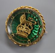 A yellow metal and green enamel regimental brooch, with ropetwist border, 22mm.