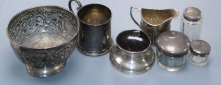 An Edwardian silver christening mug, a repousse silver bowl, a silver cream jug, mounted inkwell and