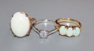 A modern 9ct gold and diamond cluster ring, a 9ct gold and three stone white opal ring and one other