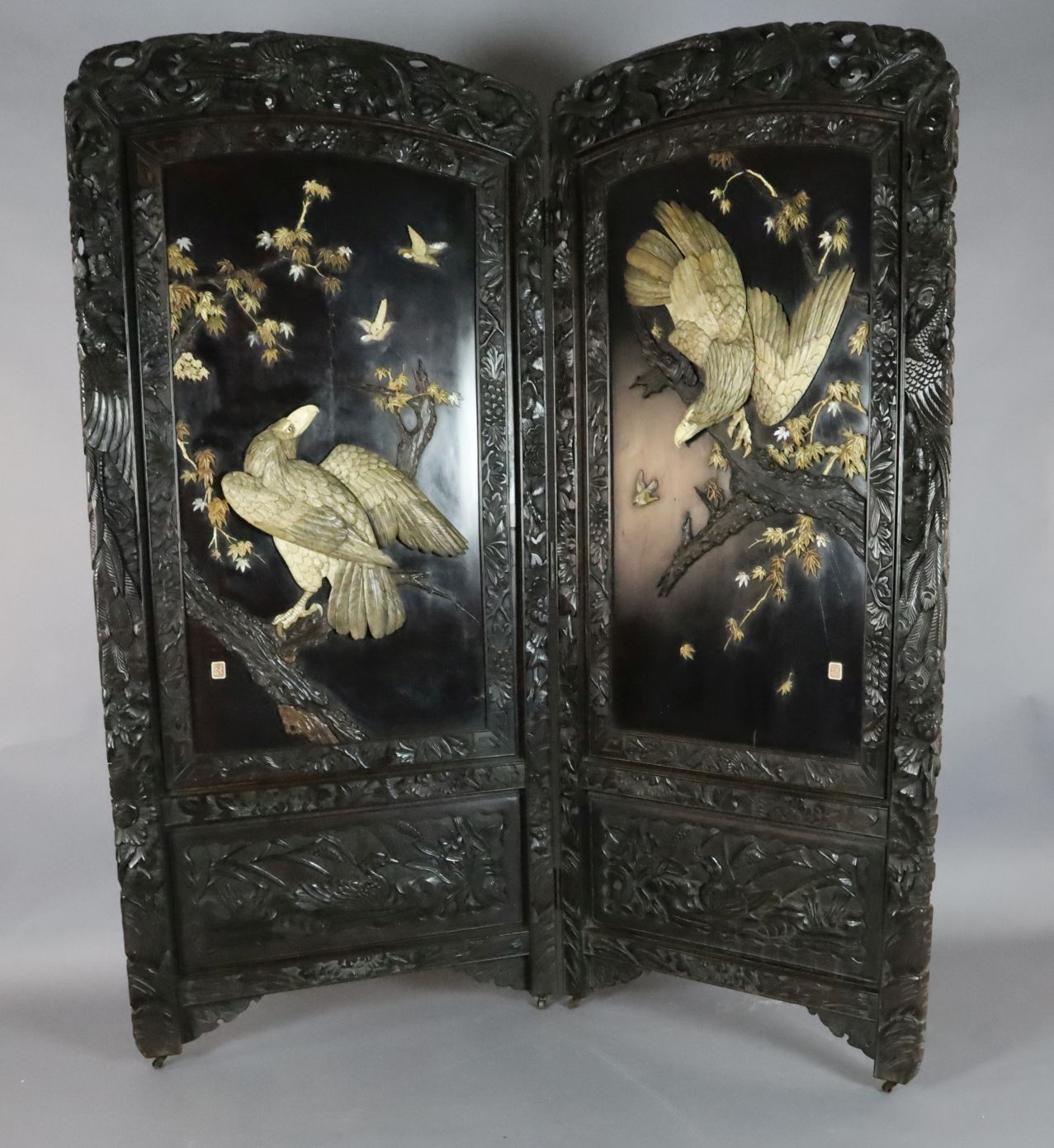 A Japanese Shibayama bi-fold screen, Meiji period, applied in ivory, bone and wood with the