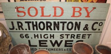 A painted wood sign, c.1960, "Sold by J. R. Thornton 66 High Street Lewes" W.183cm