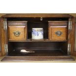 An oak smoker's cabinet with a cased meerschaum pipe