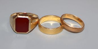 A 22ct yellow gold engraved wedding band, a similar plain band and a 9ct yellow gold signet ring