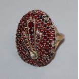 A large Victorian yellow metal and facet cut garnet encrusted oval dress ring, size R.