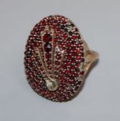 A large Victorian yellow metal and facet cut garnet encrusted oval dress ring, size R.