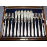 Twelve pairs of silver fish knives and forks, hollow handles, London 1928, in oak canteen.