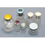 Seven assorted early 20th century silver mounted glass scent bottles including four with enamel,