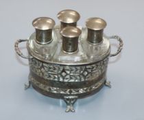 A George V pierced silver two handled scent bottle stand, Birmingham, 1928 with four mounted glass