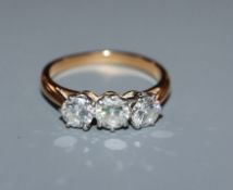 A diamond three-stone ring in yellow metal setting (tests as 18ct) size K.