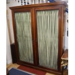 A late Victorian mahogany glazed two door bookcase with pleated fabric interior W.173cm