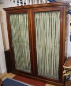 A late Victorian mahogany glazed two door bookcase with pleated fabric interior W.173cm