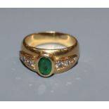 A moder 750 yellow metal, emerald and diamond set dress ring, size J/K