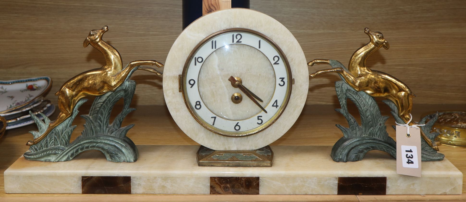 An Art Deco style onyx, marble and spelter mantel clock length 64cm