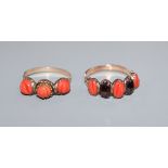 Two Georgian yellow metal and carved coral set half hoop rings, one set with coral and garnet.