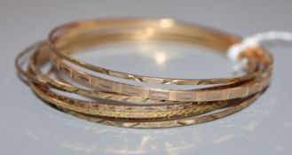 A 9ct gold narrow bangle with engine-turned decoration and seven other narrow bangles.