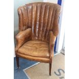 A George III mahogany hide-covered wing chair
