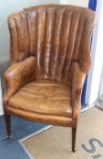 A George III mahogany hide-covered wing chair