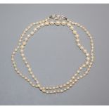 A single strand graduated cultured pearl necklace with diamond three-stone and platinum clasp 46cm.