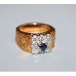 A 1970's? textured yellow metal, sapphire and diamond cluster ring, size H.