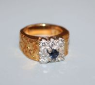 A 1970's? textured yellow metal, sapphire and diamond cluster ring, size H.