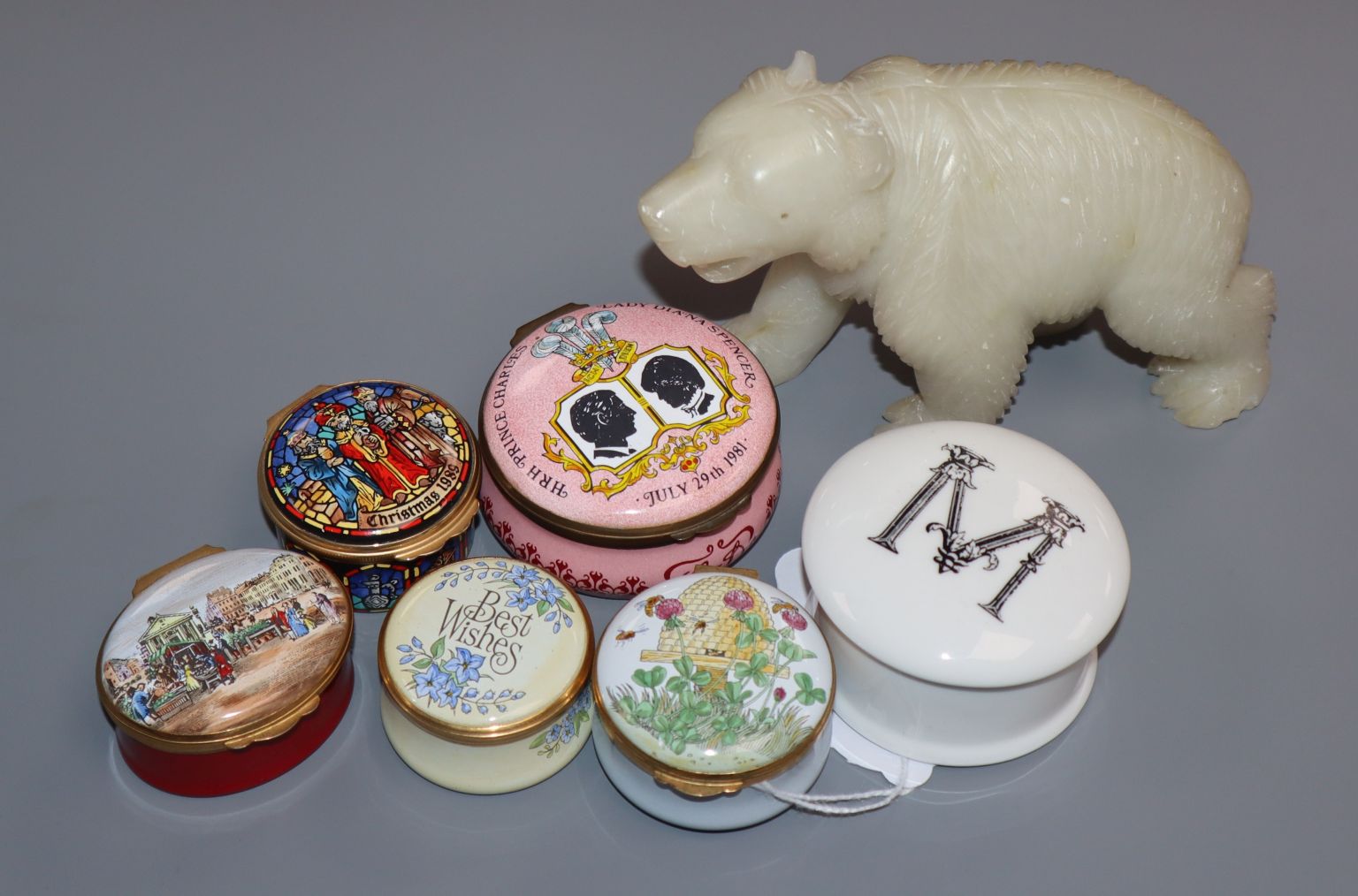 A collection of enamel pill boxes and a soapstone carved bear