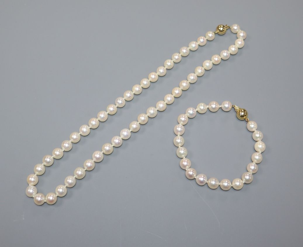 A single row uniform cultured pearl necklace with 18ct gold ball clasp and a similar bracelet with