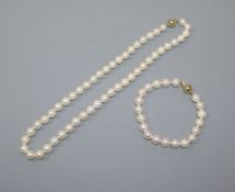 A single row uniform cultured pearl necklace with 18ct gold ball clasp and a similar bracelet with