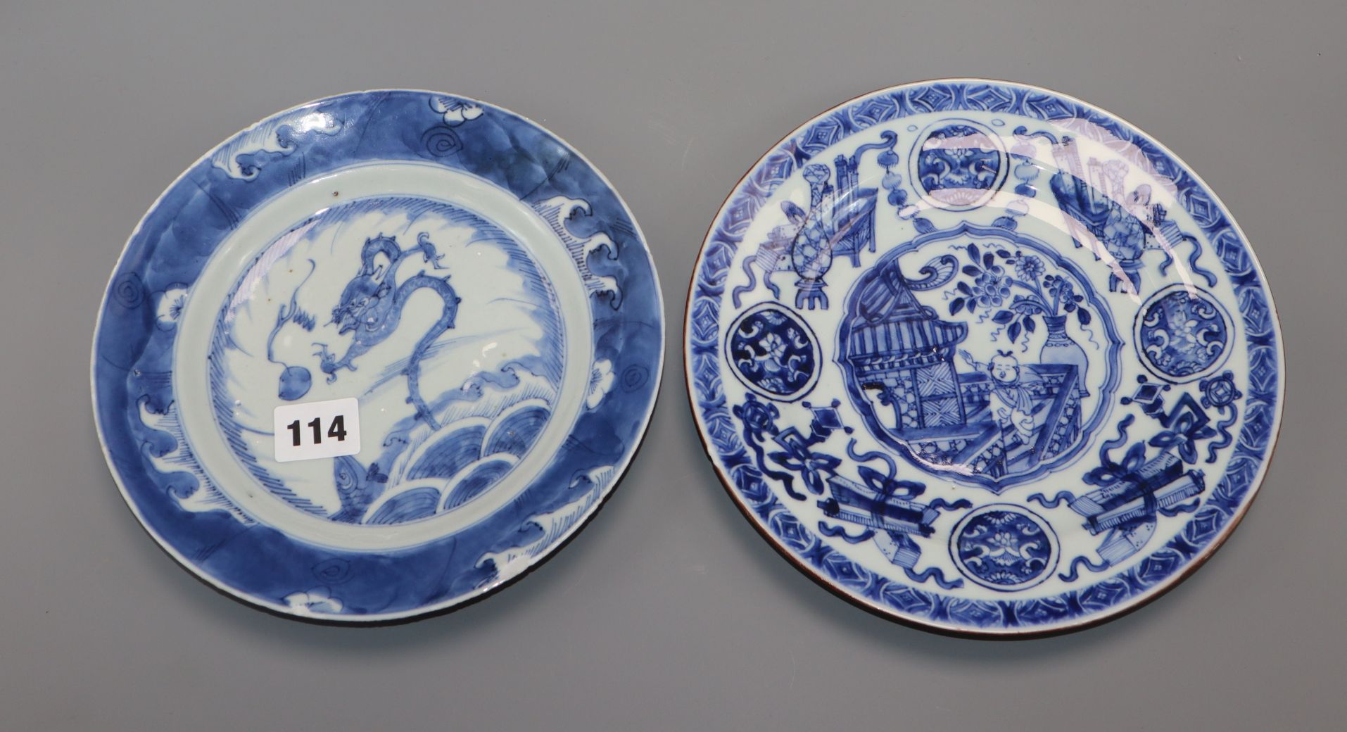 An 18th century Kangxi Chinese blue and white dragon plate and one other. largest diameter 22.5cm