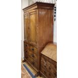 A Regency mahogany linen press having reel-turned cornice over a pair of doors enclosing trays, with