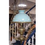 A brass hanging light and glass shade