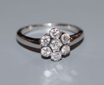 A modern 18k white gold and seven stone diamond cluster ring, size N.