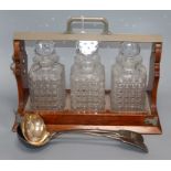 An Army and Navy three bottle tantalus and two serving spoons width 42cm