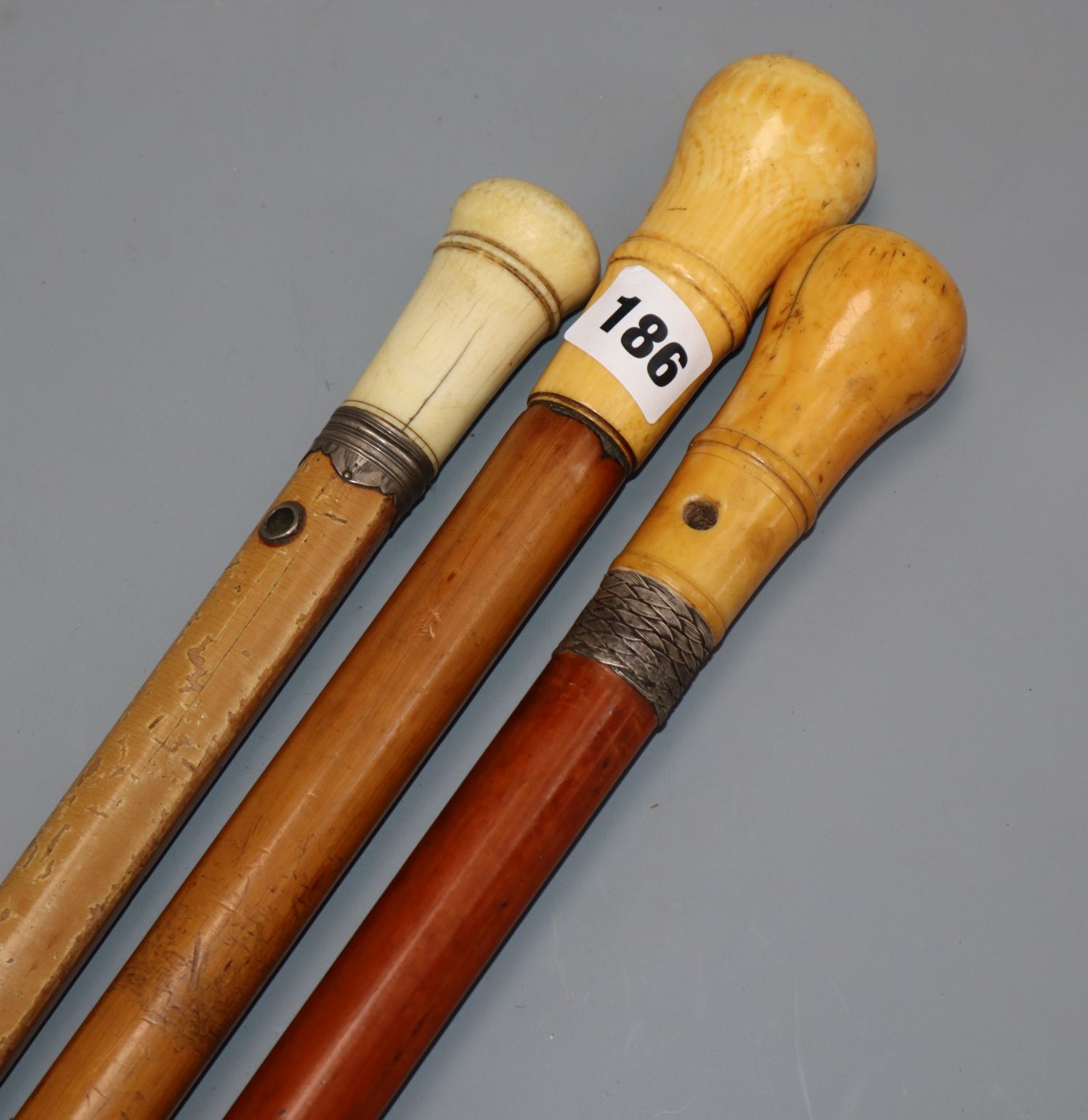 Three ivory handled malacca walking canes longest 91cm