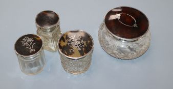 Three assorted silver and tortoiseshell pique mounted glass toilet jars and a similar salts bottle.