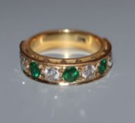 A modern 18ct yellow metal and nine stone emerald and diamond set half hoop ring, size L.