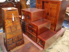 A Japanese elm cabinet, an elm cabinet of drawers of tapered form and two 'stepped' cabinets Largest