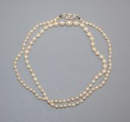 A single strand graduated cultured pearl necklace with diamond three-stone and platinum clasp 46cm.