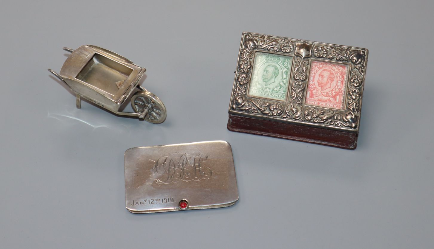 Three assorted Edwardian silver stamp cases, including a wheelbarrow, sliding case and mounted red