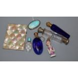 A 1930's silver and enamel pill box, four assorted mounted glass scent bottles including enamel, a