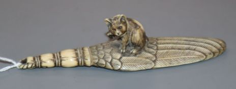 A good Japanese ivory paper knife, Meiji period, carved as a kitten seated upon a giant feather