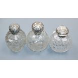 Three assorted late Victorian and later repousse silver mounted cut scent bottles including Mappin &