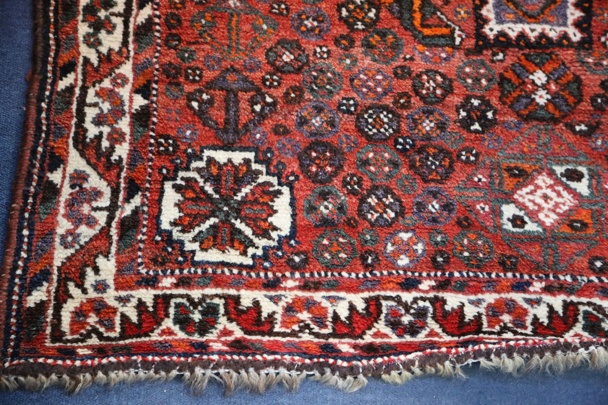 A Shiraz design red ground rug, with central polygon in a field of flower heads and three row - Image 2 of 3