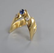 A stylish 18ct, sapphire and diamond set three stone 'chevron' ring, gross 5.7 grams, size R/S.