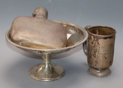 A George V silver spirit flask, a silver christening mug and a silver bon bon stand.