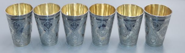 A set of six Persian engraved white metal beaker cups, height 85mm, 684 grams